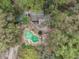 Aerial view of the property showcasing the pool, green spaces, and quaint outbuildings at 221 Se 125Th Terrace Rd, Silver Springs, FL 34488