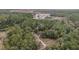 Stunning aerial shot displaying the property's location amidst a picturesque, wooded landscape with ponds at 221 Se 125Th Terrace Rd, Silver Springs, FL 34488