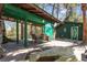 Backyard with a covered patio, dining set, green shed, and a split log seating area at 221 Se 125Th Terrace Rd, Silver Springs, FL 34488