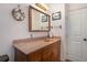 Bathroom with a wood vanity, pink counter, starfish wreath, and decorative towels at 221 Se 125Th Terrace Rd, Silver Springs, FL 34488