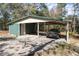 Carport and storage shed with a black car, featuring ample parking and storage at 221 Se 125Th Terrace Rd, Silver Springs, FL 34488