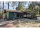 Quaint home exterior with covered porch, nestled in a natural and wooded landscape at 221 Se 125Th Terrace Rd, Silver Springs, FL 34488