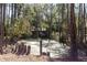 Exterior view of property with deck and pond, nestled in a serene wooded setting at 221 Se 125Th Terrace Rd, Silver Springs, FL 34488