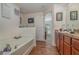Bathroom with a garden tub, wood cabinets, and a separate shower at 3829 Arborvitae Way, Deland, FL 32724