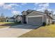 Front view of a gray one-story house with a two-car garage at 3829 Arborvitae Way, Deland, FL 32724