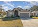 Gray one-story house with two-car garage and landscaped lawn at 3829 Arborvitae Way, Deland, FL 32724