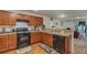 Modern kitchen with wood cabinets, granite countertops, and stainless steel appliances at 3829 Arborvitae Way, Deland, FL 32724