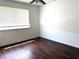 A cozy bedroom with dark wood-look flooring, a window with blinds, and a ceiling fan at 5123 Picadilly Circus Ct # 2, Orlando, FL 32839