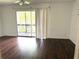 Bright bedroom with wood-look flooring, ceiling fan, and sliding glass doors to a balcony at 5123 Picadilly Circus Ct # 2, Orlando, FL 32839