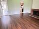 Open-concept living area with wood-look flooring, a brick fireplace, and kitchen view at 5123 Picadilly Circus Ct # 2, Orlando, FL 32839
