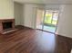 Spacious living room with wood-look flooring, a brick fireplace, and sliding glass doors at 5123 Picadilly Circus Ct # 2, Orlando, FL 32839