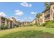 Condo building with grassy lawn and palm trees at 570 Orange Dr # 54, Altamonte Springs, FL 32701