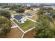 An aerial view shows a home surrounded by mature trees and a large backyard with a white fence at 10339 Castillo Ct, Clermont, FL 34711