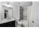 Well-lit bathroom featuring wood-look tile accent wall, bathtub, shower, sink, and dark-colored vanity at 10339 Castillo Ct, Clermont, FL 34711