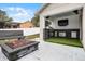 Covered outdoor kitchen and fire pit featuring a stone surround, concrete pavers and artificial turf at 10339 Castillo Ct, Clermont, FL 34711