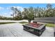 Outdoor fire pit surrounded by concrete pavers and a built-in bench, perfect for entertaining at 10339 Castillo Ct, Clermont, FL 34711
