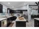 Modern kitchen with stainless steel appliances, center island, and dark cabinetry open to the adjacent dining room at 10339 Castillo Ct, Clermont, FL 34711