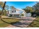 Front exterior view showcasing a well-manicured lawn, driveway, lush landscaping, and attached garage at 11036 Schooner Way, Windermere, FL 34786