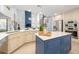 Open-concept kitchen boasts a blue island, stainless steel appliances, and seamless flow to living area at 11036 Schooner Way, Windermere, FL 34786