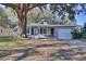 Ranch home with screened porch and mature oak tree in front yard at 1246 Margina Ave, Daytona Beach, FL 32114