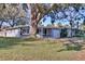 Gray house with large oak tree, screened porch, and attached garage at 1246 Margina Ave, Daytona Beach, FL 32114