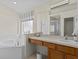 Bathroom with a large vanity, a soaking tub, and a walk-in shower at 164 Sevilla Ave, Davenport, FL 33897
