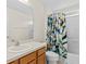 Clean bathroom with wood vanity, shower/tub combo, and bird-themed shower curtain at 164 Sevilla Ave, Davenport, FL 33897