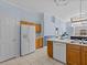 White appliances and wood cabinets in a kitchen with an island at 164 Sevilla Ave, Davenport, FL 33897