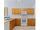 Kitchen features wood cabinets, white appliances, and a double sink at 164 Sevilla Ave, Davenport, FL 33897