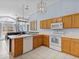 Kitchen with wood cabinets, white appliances, and tile floor at 164 Sevilla Ave, Davenport, FL 33897