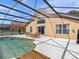 Screened pool and patio area with wooden furniture at 164 Sevilla Ave, Davenport, FL 33897