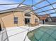 Screened pool and patio area with wooden furniture at 164 Sevilla Ave, Davenport, FL 33897