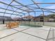 Screened pool and patio area with wooden furniture at 164 Sevilla Ave, Davenport, FL 33897