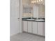 Bathroom with double vanity, updated tile floors, and a large mirror at 16946 Woodcrest Way, Clermont, FL 34714