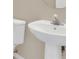 Small bathroom with pedestal sink and toilet at 16946 Woodcrest Way, Clermont, FL 34714