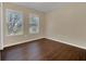 Bright bedroom with dark wood floors and two large windows at 16946 Woodcrest Way, Clermont, FL 34714