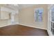 Living room with dark laminate floors and large windows at 16946 Woodcrest Way, Clermont, FL 34714