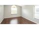 Simple bedroom with dark wood-look floors and large window at 1747 Lady Slipper Cir, Orlando, FL 32825