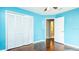 Bedroom featuring wood floors, blue walls, and a closet at 1747 Lady Slipper Cir, Orlando, FL 32825