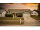 House exterior at sunset, featuring a two-car garage and front yard at 1747 Lady Slipper Cir, Orlando, FL 32825