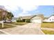 One story home with a green exterior, two car garage, and neatly landscaped yard at 1747 Lady Slipper Cir, Orlando, FL 32825