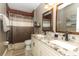Bathroom with granite countertops, double sinks, and a beige tiled shower at 355 Carriage Way Ct, Oviedo, FL 32765