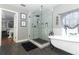 Spa-like bathroom featuring a glass shower, freestanding tub, and dark grey floor tiles at 355 Carriage Way Ct, Oviedo, FL 32765