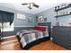 Modern bedroom with grey walls, hardwood floors, and red and grey bedding at 355 Carriage Way Ct, Oviedo, FL 32765