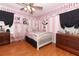 Charming bedroom with Parisian decor, hardwood floors, and a white bed frame at 355 Carriage Way Ct, Oviedo, FL 32765