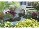 Landscaped walkway leading to a house entrance with lush tropical plants at 355 Carriage Way Ct, Oviedo, FL 32765