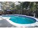 Relaxing kidney-shaped pool with a waterfall feature and screened enclosure at 355 Carriage Way Ct, Oviedo, FL 32765