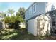 Storage shed and small citrus tree in grassy side yard at 355 Carriage Way Ct, Oviedo, FL 32765