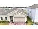 Tan two-story house with a two-car garage and a brick driveway at 3653 Yarian Dr, Haines City, FL 33844