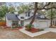 Two-story house with white exterior, black roof, landscaping, and large tree at 5100 Neponset Ave, Orlando, FL 32808